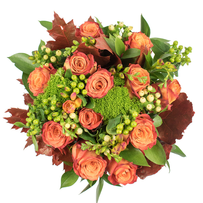 From a direct overhead angle the bouquet reads like a small, cultivated landscape - a carefully composed circle of autumn colour set against pristine white. The focal point is a cluster of large, fully bloomed roses whose cores glow with soft peach and coral, their outer petals shaded into deeper orange and a reddish-rust that evokes Bracknell's late autumn trees. Interspersed among the roses are compact spheres of hypericum berries, some a vivid lime-green that brightens the eye, others a gentle cream that softens the overall palette. Plush mounds of green trick dianthus sit low among the stems, their velvety, moss-like texture offering visual rest and tactile intrigue. A foundation of fresh, glossy green foliage cushions the blooms, while more substantial, lobed leaves in burgundy and burnt orange are placed deliberately to suggest fallen leaves and to introduce a darker tonal anchor. The arrangement's dense, rounded silhouette catches soft, diffused light which skims petal edges and brings out the roses' velvety sheen without losing the intimate shadows between blooms. The scent is subtly floral with an undercurrent of green moss and dry leaf - a fragrance suited to an evening table at home or an elegant seasonal gift for clients in Bracknell's town centre or residents near Crown Wood. Meticulous in its layering and balanced in texture, this bouquet is a study in autumnal harmony: warm, composed, and richly textured, ideal for Thanksgiving dining rooms or a tasteful seasonal accent in a home where botanical detail matters.